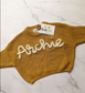 hand embroidered mustard childrens knit jumper with archie embroidered on front in cream white